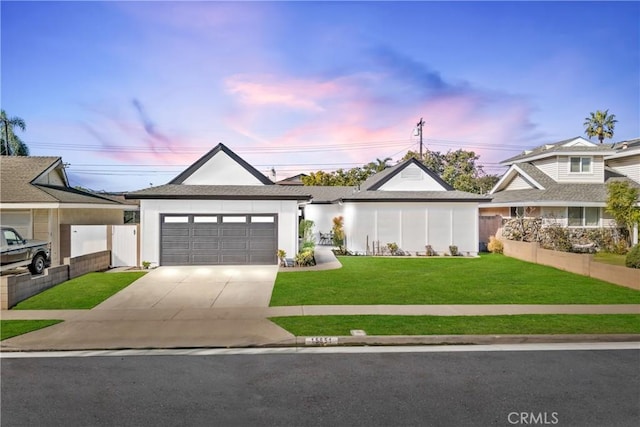 view of front of home featuring driveway, an attached garage, fence, and a front yard