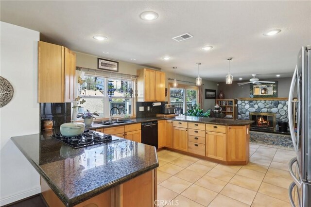 5020 Solitude Ct, Rancho Cucamonga, CA 91737 - kitchen with a peninsula, black appliances, ceiling fan, a stone fireplace, and a sink