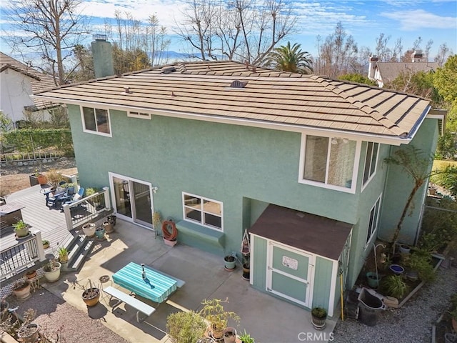 5020 Solitude Ct, Rancho Cucamonga, CA 91737 - back of property featuring stucco siding, a tile roof, a chimney, and a wooden deck