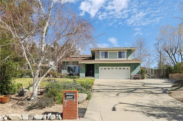 view of front of home featuring driveway, a garage, fence, and stucco siding