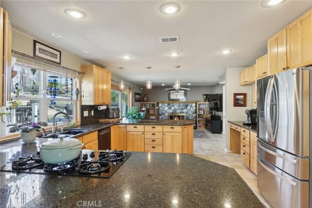 5020 Solitude Ct, Rancho Cucamonga, CA 91737 - kitchen featuring black appliances, a peninsula, light brown cabinetry, recessed lighting, and a stone fireplace