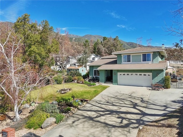 view of front of property with driveway, a front lawn, an attached garage, and a mountain view