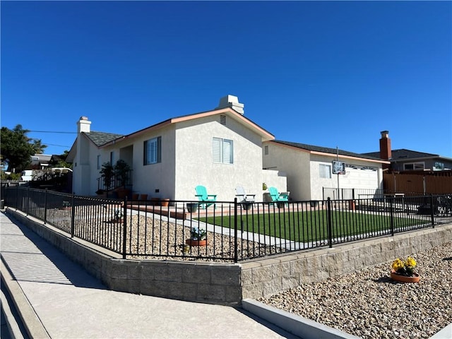 view of front facade with fence, a front lawn, and stucco siding