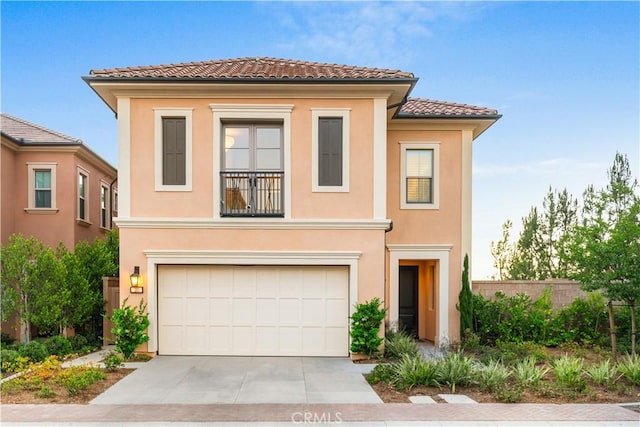 mediterranean / spanish home featuring a tiled roof, fence, concrete driveway, and stucco siding