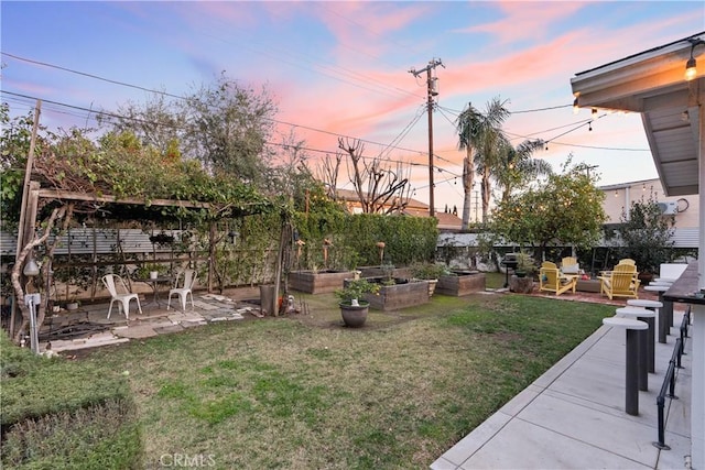 view of yard with a patio area, fence, and a garden