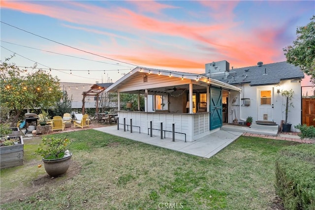 rear view of house with a patio area, a lawn, outdoor dry bar, and central AC unit