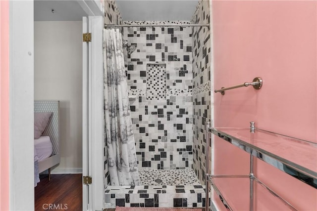 full bath featuring ensuite bath, a shower stall, and wood finished floors