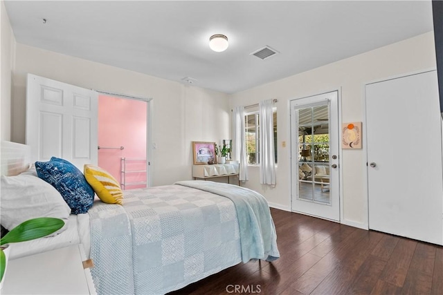 bedroom featuring dark wood-style flooring, visible vents, and access to exterior