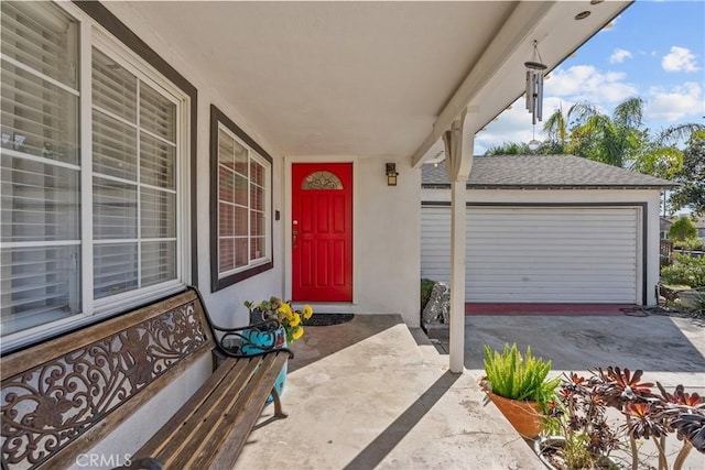 view of exterior entry featuring a garage and stucco siding