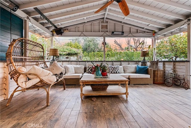 sunroom with lofted ceiling with beams and a ceiling fan