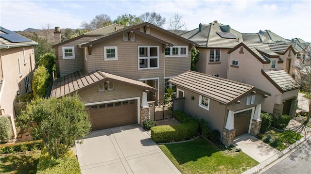 craftsman house featuring a standing seam roof, concrete driveway, an attached garage, metal roof, and a chimney