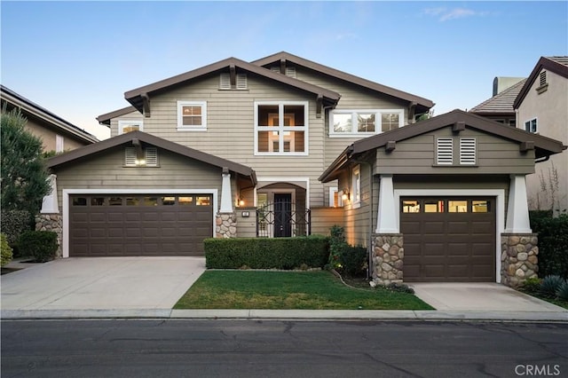 craftsman inspired home with stone siding, a garage, and driveway