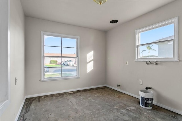 spare room featuring plenty of natural light and baseboards