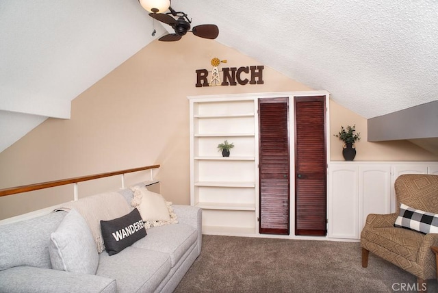 living area with a ceiling fan, lofted ceiling, carpet flooring, and a textured ceiling