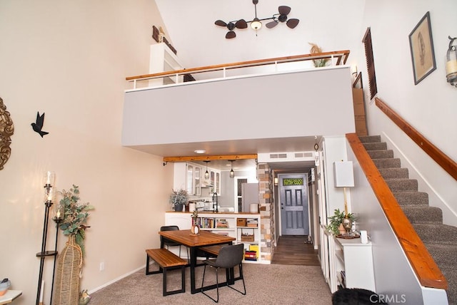 interior space with a high ceiling, stairway, visible vents, and baseboards