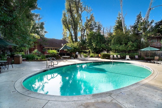 community pool featuring a patio and fence