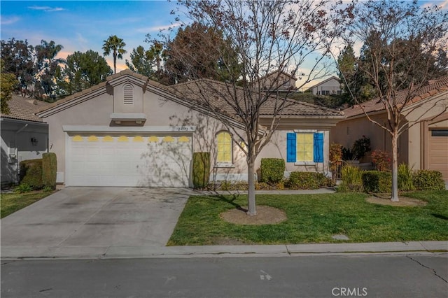 view of front of property featuring a garage, concrete driveway, a tile roof, and stucco siding