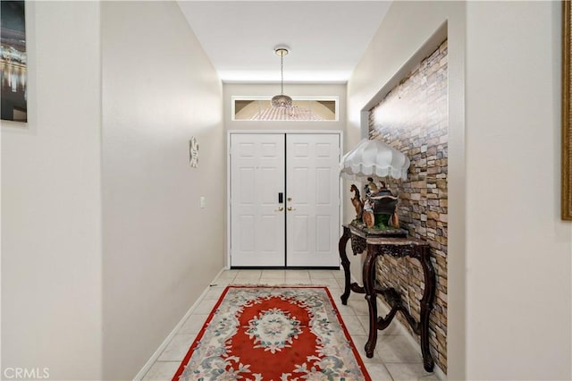 entryway with baseboards and light tile patterned floors