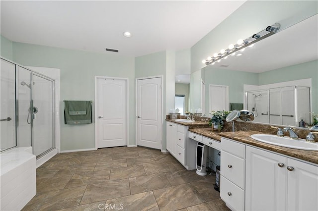 bathroom with a stall shower, visible vents, a sink, and double vanity