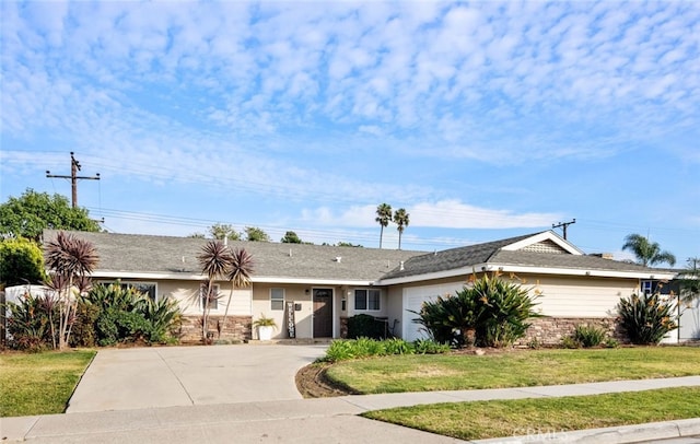 single story home with a garage, stone siding, a front lawn, and concrete driveway