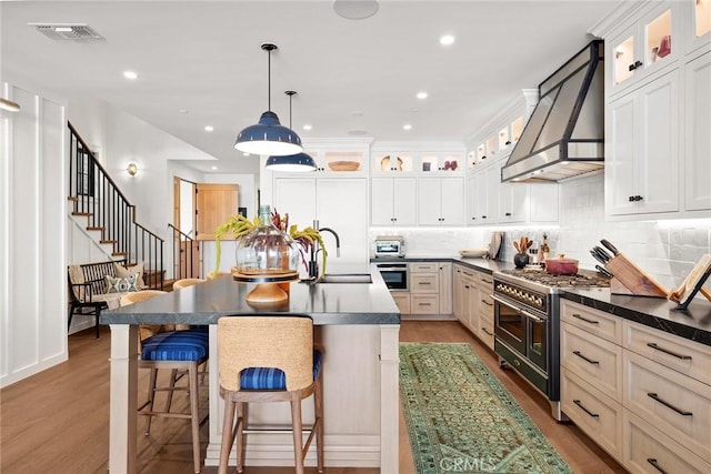 kitchen featuring dark countertops, glass insert cabinets, and range with two ovens