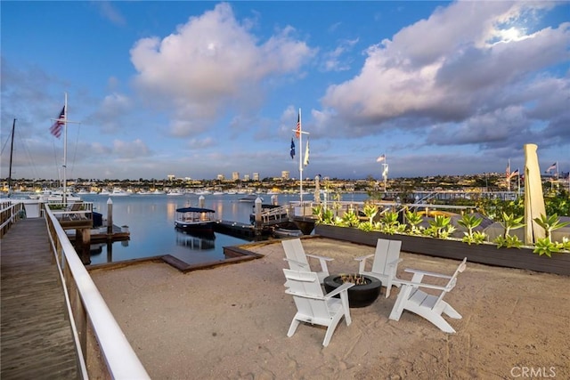 view of dock with a water view and a fire pit