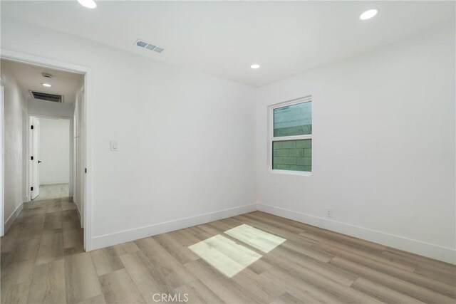 spare room featuring baseboards, light wood-style flooring, visible vents, and recessed lighting