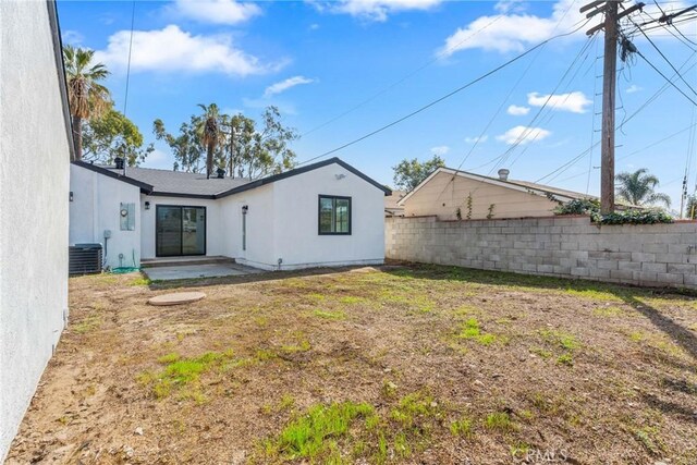 back of house with a patio, a fenced backyard, central air condition unit, a lawn, and stucco siding