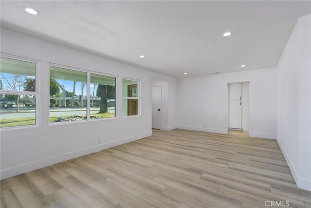 unfurnished room featuring light wood-style flooring, baseboards, and recessed lighting