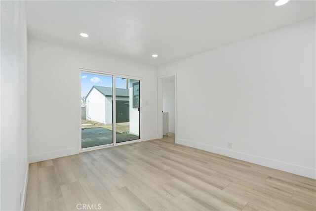 spare room featuring recessed lighting, light wood-style flooring, and baseboards