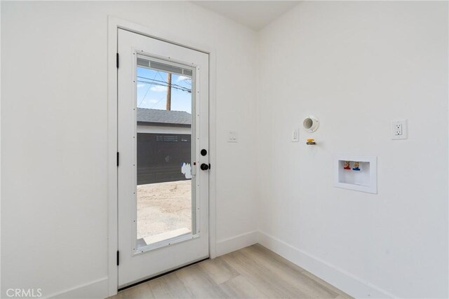 doorway to outside featuring light wood-style flooring and baseboards