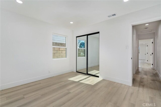 unfurnished bedroom with recessed lighting, light wood-type flooring, visible vents, and baseboards