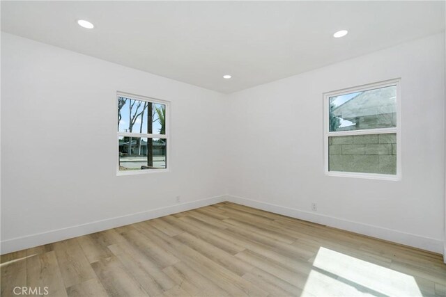 spare room with light wood-style floors, recessed lighting, and baseboards