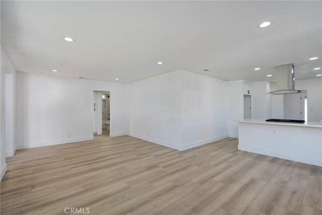 unfurnished living room with light wood-type flooring, baseboards, and recessed lighting