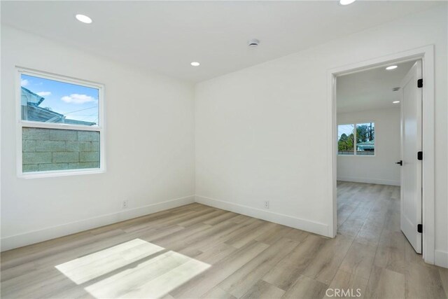 spare room with light wood-type flooring, baseboards, and recessed lighting