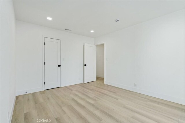 unfurnished bedroom featuring baseboards, light wood-type flooring, and recessed lighting