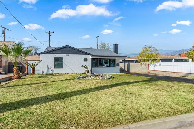 single story home with fence, a chimney, a front lawn, and stucco siding