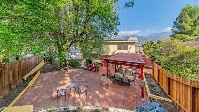 view of patio / terrace with outdoor dining area, a fenced backyard, and a mountain view