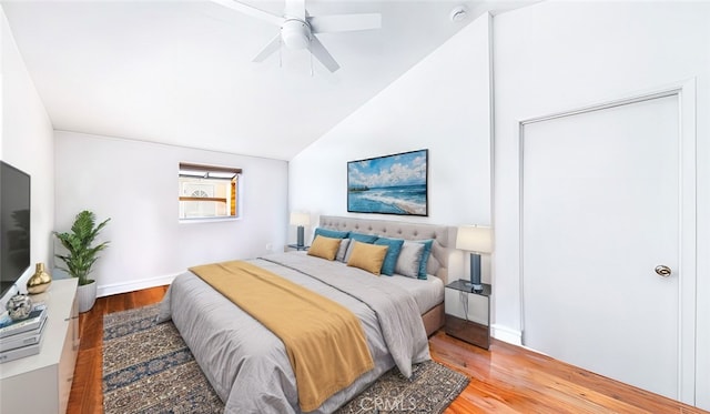 bedroom with ceiling fan, baseboards, lofted ceiling, and wood finished floors