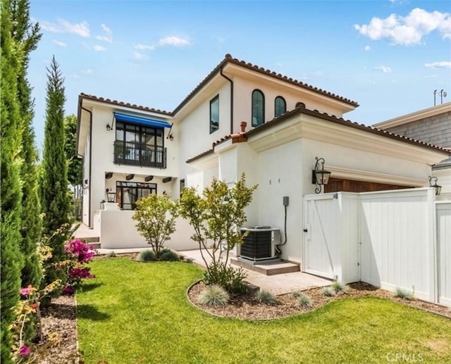 rear view of house featuring a yard, central AC unit, a gate, a patio area, and fence