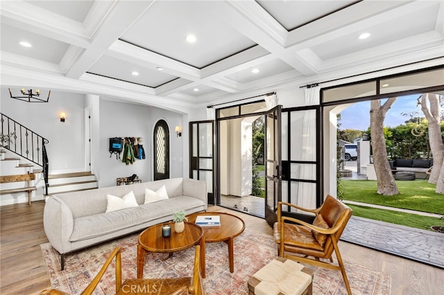 living room with coffered ceiling, beamed ceiling, stairway, and wood finished floors