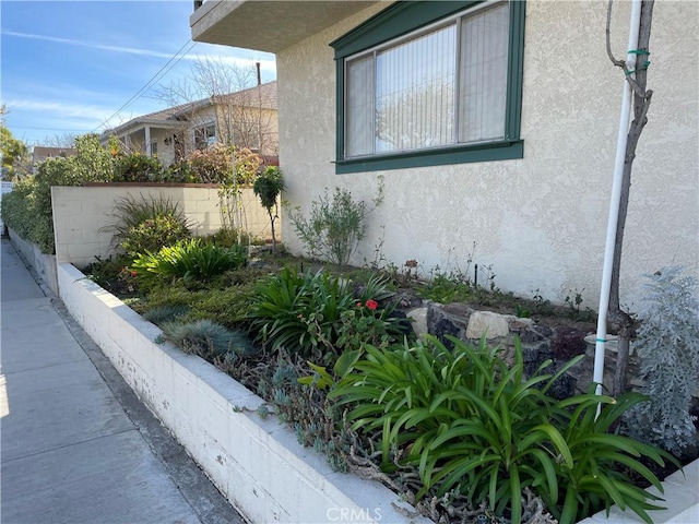 view of property exterior featuring fence and stucco siding