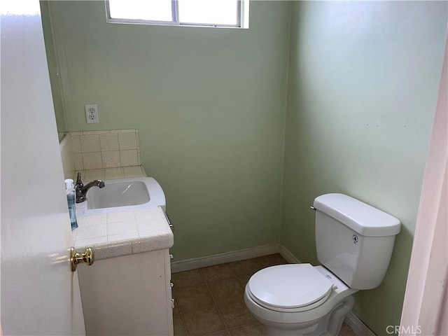 bathroom with tile patterned floors, baseboards, toilet, and vanity