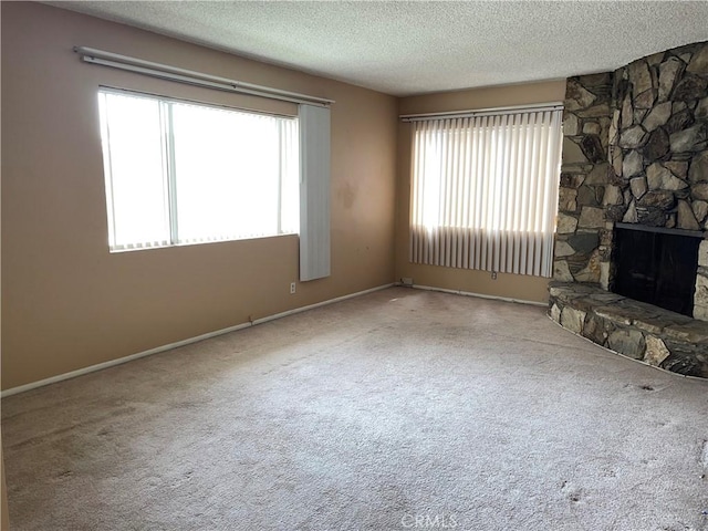 unfurnished living room featuring a textured ceiling, carpet, and baseboards