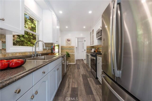 kitchen featuring stainless steel appliances, white cabinets, and a sink