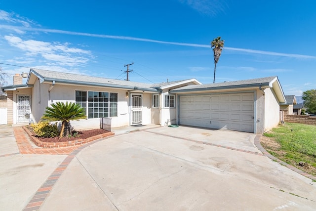 ranch-style home featuring driveway, an attached garage, and stucco siding