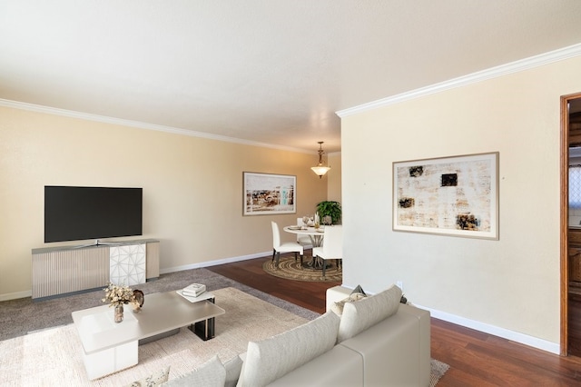 living area featuring crown molding, baseboards, and wood finished floors