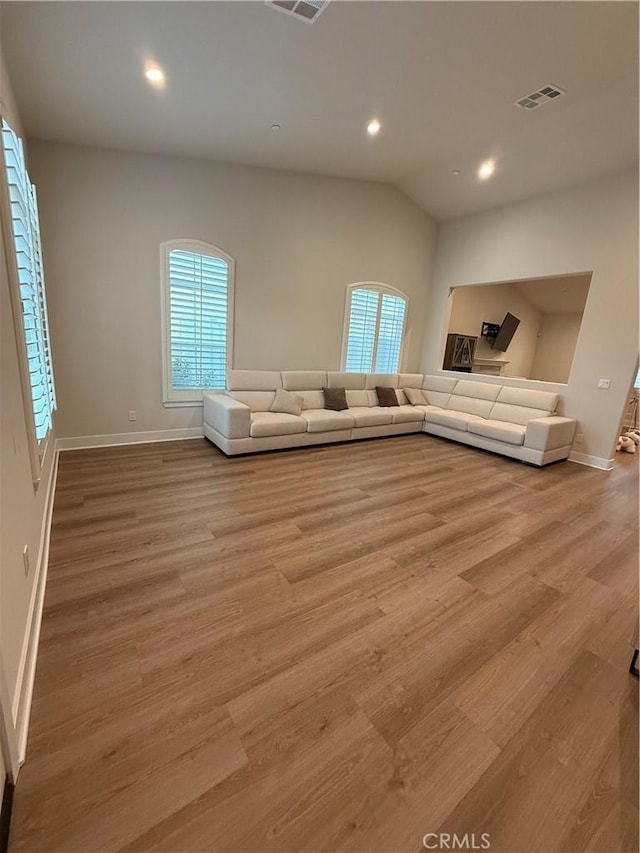 unfurnished living room with light wood finished floors, recessed lighting, visible vents, and a healthy amount of sunlight