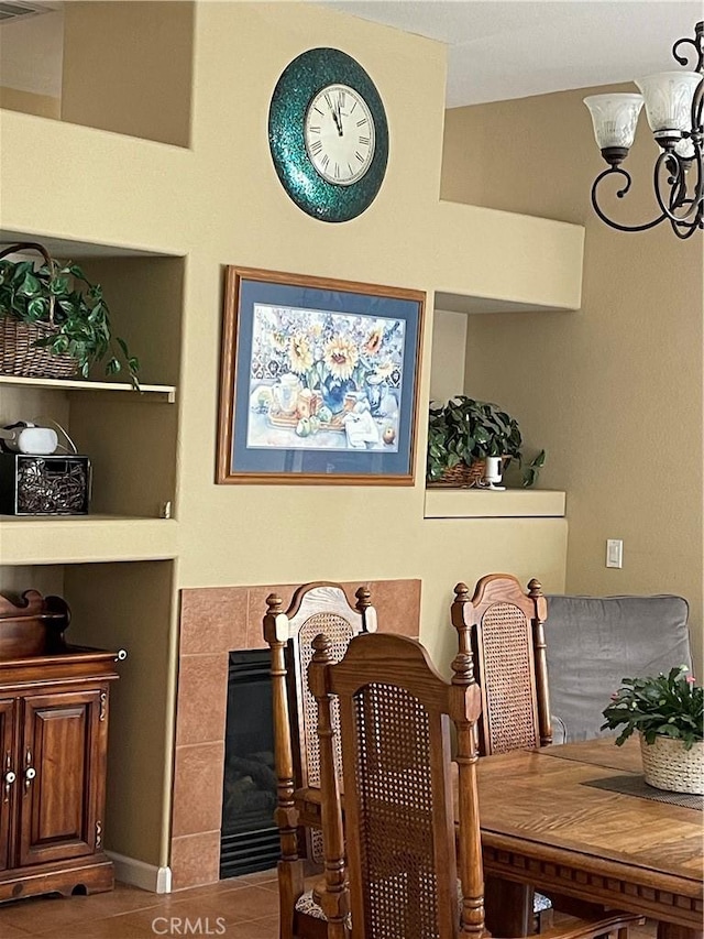 dining room with a tiled fireplace and an inviting chandelier