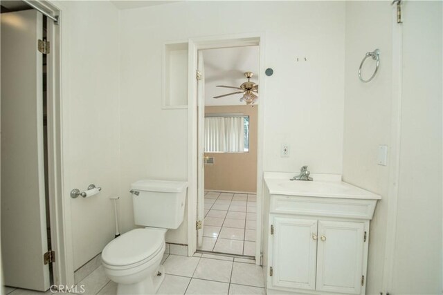 half bathroom featuring ceiling fan, tile patterned flooring, toilet, vanity, and baseboards